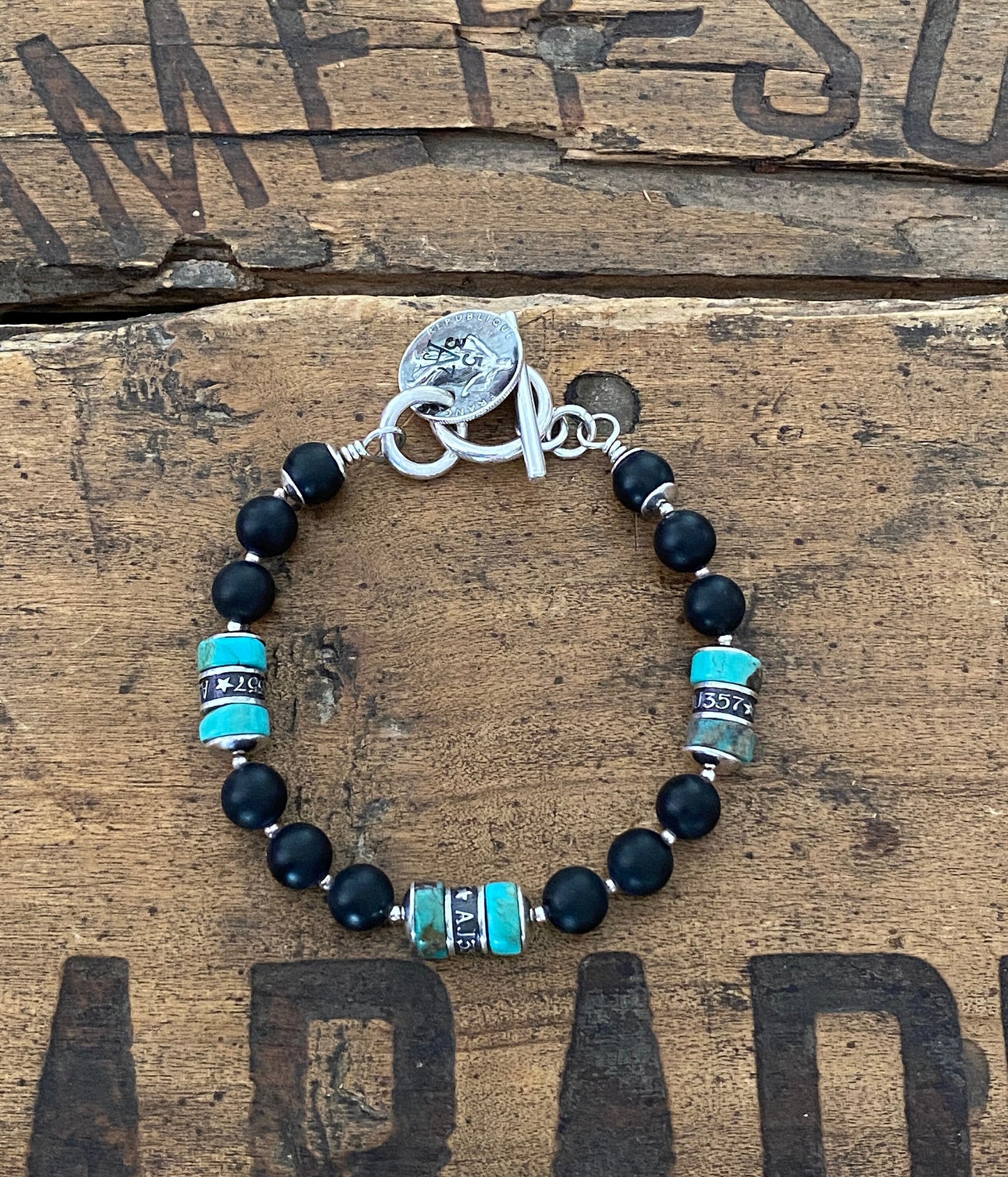 The Pacific Bracelet is made of, Turquoise, sterling silver, Vintage silver coin and Obsidian 8mm Beads.
